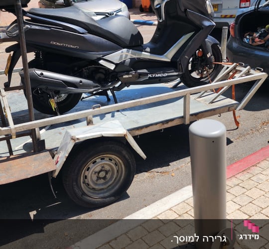 קטנוע על נגרר חונה בצד הדרך